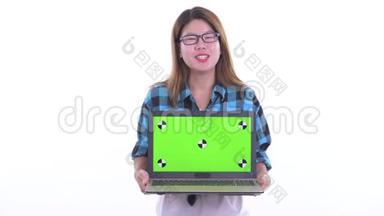 快乐的年轻亚洲<strong>潮女</strong>一边说一边展示笔记本电脑